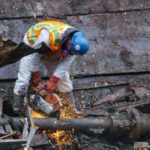 A worker cuts through a pipe on the tug Challenger on March 8, 2016 (Photo by David Purdy/KTOO)