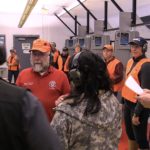 Cathy Tilton and her team listen to a briefing before the handgun event during the 19th Annual Legislative Team Shoot. (Photo by David Purdy/KTOO)
