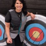 Cathy Tilton poses in front of her target at the Juneau Hunter Education Shooting Complex during the 19th Annual Legislative Team Shoot. (Photo by David Purdy/KTOO)