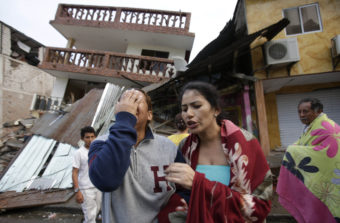 A woman cries as she stands next to a house destroyed by the earthquake in the Pacific coastal town of Pedernales, Ecuador on Sunday. Dolores Ochoa/AP