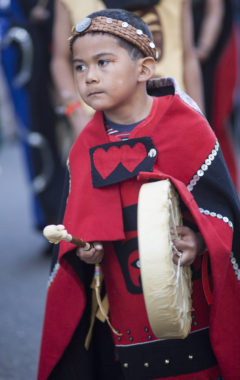 Max Wesley, 7, drums during a processional and grand entrance on Wednesday, June 8, 2016, near Juneau, Alaska. Celebration is a biennial festival of Tlingit, Haida and Tsimshian tribal members put on by the Sealaska Heritage Institute. (Photo by Rashah McChesney/KTOO)