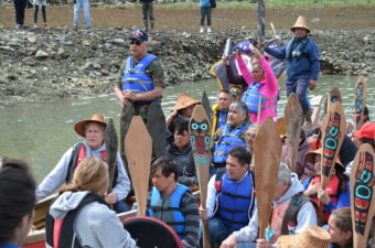 Governor Bill Walker joined a canoe carrying veterans from across Southeast. Holding high the American flag, they honored WWII veteran, Frank Jack Sr., who passed away the night before. (Photo by Emily Kwong/KCAW)