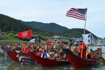 Tlingit master carver Wayne Price carved the two red canoes on the end.They joined the flotilla as they made their entrance into Douglas. (Photo By Emily Kwong/KCAW)
