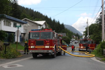 Neighbors gathered to watch the firefighters extinguish the flames. (Photo by Elizabeth Jenkins/KTOO)
