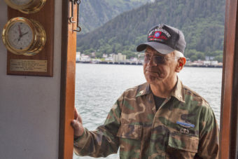 Dennis Jack, Tlingit from Angoon, stands in the doorway of the Princeton Hall, a safety boat, on Wednesday, June 8, 2016, near Juneau, Alaska. The One People Canoe Society group began the trip to Juneau from Angoon on June 2. Jack is one of several Alaska Native veterans who flew a flag honoring their brethren during the trip which is the unofficial beginning of Celebration. (Photo by Rashah McChesney/KTOO)