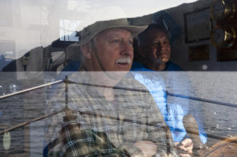 Harry James drives the Princeton Hall, while Ed Thomas, former President of the Central Council of the Tlingit and Haida Indian Tribes of Alaska looks on Wednesday, June 8, 2016, near Juneau, Alaska. The One People Canoe Society group began the trip to Juneau from Angoon on June 2. Their landing on Douglas Island is the unofficial beginning of Celebration. (Photo by Rashah McChesney/KTOO)