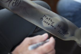 Kathy Ruddy, owner of the Princeton Hall, signs a ceremonial paddle on Wednesday, June 8, 2016, near Juneau, Alaska. Ruddy's boat was one of several that followed the One People Canoe Society group to provide safety and oversight during a trip from Juneau from Angoon. The group's landing on Douglas Island is the unofficial beginning of Celebration. (Photo by Rashah McChesney/KTOO)