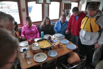 Paddlers in a canoe honoring Alaska Native veterans share a prayer and a meal before getting into their canoe to finish paddling from Angoon to Juneau on Wednesday, June 8, 2016, near Juneau, Alaska. The One People Canoe Society group began the trip on June 2. Their landing on Douglas Island is the unofficial beginning of Celebration. (Photo by Rashah McChesney/KTOO)