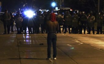A protester faces police officers on Sunday in Milwaukee, during a protest held for Sylville Smith, who was shot and killed by a police officer as he reportedly attempted to flee during a traffic stop Saturday afternoon. (Bilgin S. Sasmaz, Anadolu Agency, Getty Images)