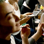 Stephanie Davis applies a stippling makeup effect to her jawline to create the illusion of facial hair stubble. Davis, who portrayed Stevie Smalls, one of the drag kings in the Femme Fatale show Friday at Rendezvous in downtown Juneau. (Photo by Tripp J Crouse/KTOO)
