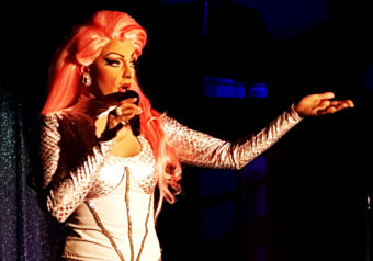 GiGi Monroe, portrayed by James Hoagland, takes a moment during Friday's amateur drag show to talk about Alaskan AIDS Assistance Association. (Photo by Tripp J Crouse/KTOO)