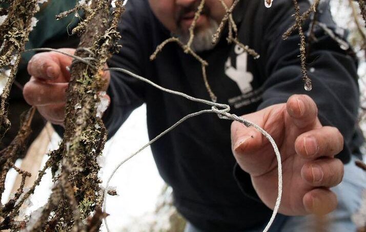 Yaghanen Youth Program Coordinator Michael Bernard teaches campers how to set a small mammal snare during one of the camp's educational sessions in October 2016. (Photo by Scott Moon/Kenaitze Indian Tribe)