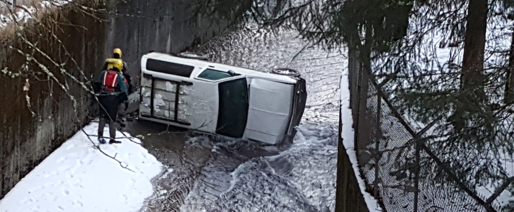 Authorities inspect the area around a vehicle found on its side in Gold Creek near Cope Park on Wednesday, Dec. 14, 2016. (Photo by Tripp J Crouse/KTOO)