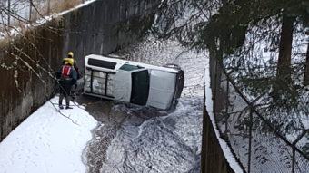 Authorities inspect the area around a vehicle found on its side in Gold Creek near Cope Park on Wednesday, Dec. 14, 2016. (Photo by Tripp J Crouse/KTOO)