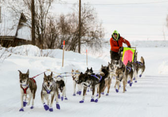 Wade Marrs was the first musher to reach the Ruby checkpoint of the Iditarod, coming off the Yukon River into town at sunset. (Photo by Zachariah Hughes/Alaska Public Media)