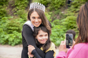 Miss Alaska USA Alyssa London poses with Juneau Community Charter School student Adrienne Whicker as her grandmother Alice Sollie takes their photo on Thursday, May 25, 2017, at Sandy Beach in Douglas.