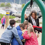 Miss Alaska USA Alyssa London pushes Juneau Community Charter School students on playground equipment on Thursday, May 25, 2017, at Sandy Beach.