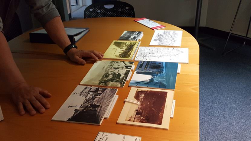 Mark Whitman shows Kathy Buell a collection of images documenting the life of Chew Chung Thui, more commonly known as China Joe. Joe was a Chinese immigrant who settled in Juneau and owned a bakery. In 1882, Congress passed the Chinese Exlusion Act, suspending Chinese immigrants for 10 years, and an anti-Chinese sentiment ran all but Joe out of town. (Photo by Tripp J Crouse/KTOO)