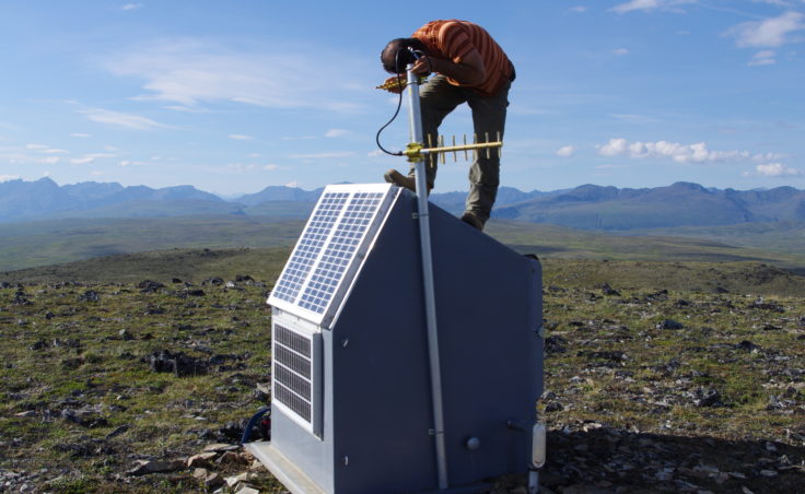 Field engineer Scott Dalton adjusts a radio communications link at a seismic station south of Cantwell.