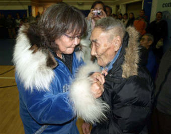 Caroline Hoover proudly pins an Alaska Territorial Guard medal on the front of her father's parka during an official discharge ceremony held Oct. 17 in Kipnuk, Alaska. David Martin is one of three surviving members of the Alaska Territorial Guard's Kipnuk unit. A total of 59 residents of Kipnuk, who volunteered to defend Alaska in the event of a Japanese invasion during World War II, were recognized during the ceremony. Kipnuk residents who served with the Alaska Territorial Guard from 1942-1947 were members of a U.S. Army component organized in response to attacks by the Japanese on Pearl Harbor. (Photo by Jerry Walton, Department of Military and Veterans Affairs cultural resource manager and native liaison/public domain/Wikimedia Commons)