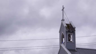 A cross tops the steeple of the Catholic Cathedral of the Nativity of the Blessed Virgin Mary in downtown Juneau on July 15, 2017. (Photo by Jeremy Hsieh/KTOO)