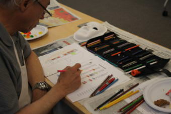John Main plans out his mask design. (Photo by Henry Leasia/Alaska Public Media)
