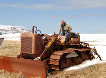 Mike Coffey poses on an old bulldozer in the Bethel area in 2009. He's retiring from his job as Department of Transportation Southcoast Region director. (Photo courtesy Department of Transportation)