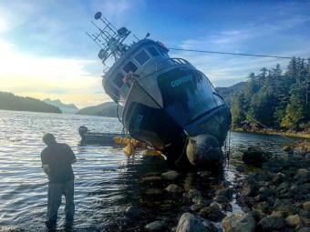The seiner Confidence is high and dry on Highwater Island in Neva Strait Sunday, August 6. The 70,000-pound cargo of pink salmon spoiled, and were disposed of in federal waters offshore. (Photo by Maxwell K. Johnson/KCAW)