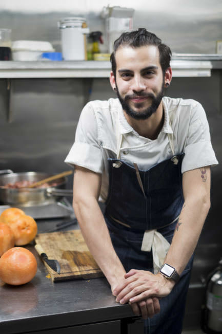 Sous chef Jacob Pickard prepares the night's scallop special in Salt's kitchen in Juneau on Aug. 9, 2017. Pickard and head chef Lionel Uddipa won the 2017 Great American Seafood Cook-off in New Orleans for a risotto that included a black cod fish sauce created by Pickard. (Photo by Annie Bartholomew/KTOO)