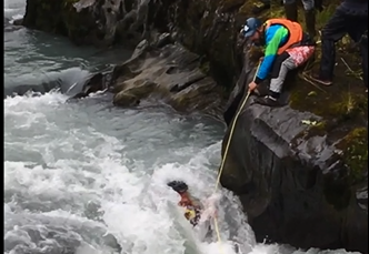 Obadiah Jenkins tries to help Daniel Hartung pull himself from Six-Mile Creek in Hope. (Photo courtesy James Bennett)