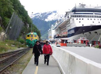 Tourists walk on Skagway’s railroad dock in summer of 2016. The cliff, where a rockslide occurred Aug. 26, is adjacent to Skagway’s biggest cruise ship dock. (Photo by Emily Files/KHNS)