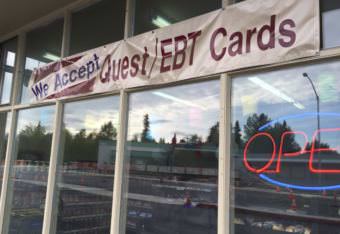 A sign outside of a store in midtown Anchorage announcing that they accept EBT Cards, the distribution method for SNAP benefits. (Photo by Hillman/Alaska Public Media)