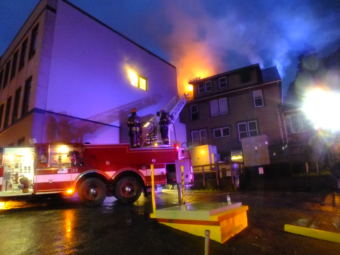 Capital City Fire/Rescue bring in a ladder truck to work on flare ups and hot spots during a house fire at 526 Seward Street on Sept. 17, 2017. (Photo by Matt Miller/KTOO)