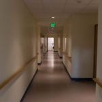 A long white hallway with doors opening off it