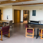 Round tables with chairs around them in a larger room with a linoleum floor