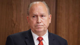 Alaska Gov. Bill Walker listens as Department of Revenue Commissioner Randall Hoffbeck discusses a compromise budget proposal with reporters in the cabinet room of the Capitol in Juneau on June 6, 2017.