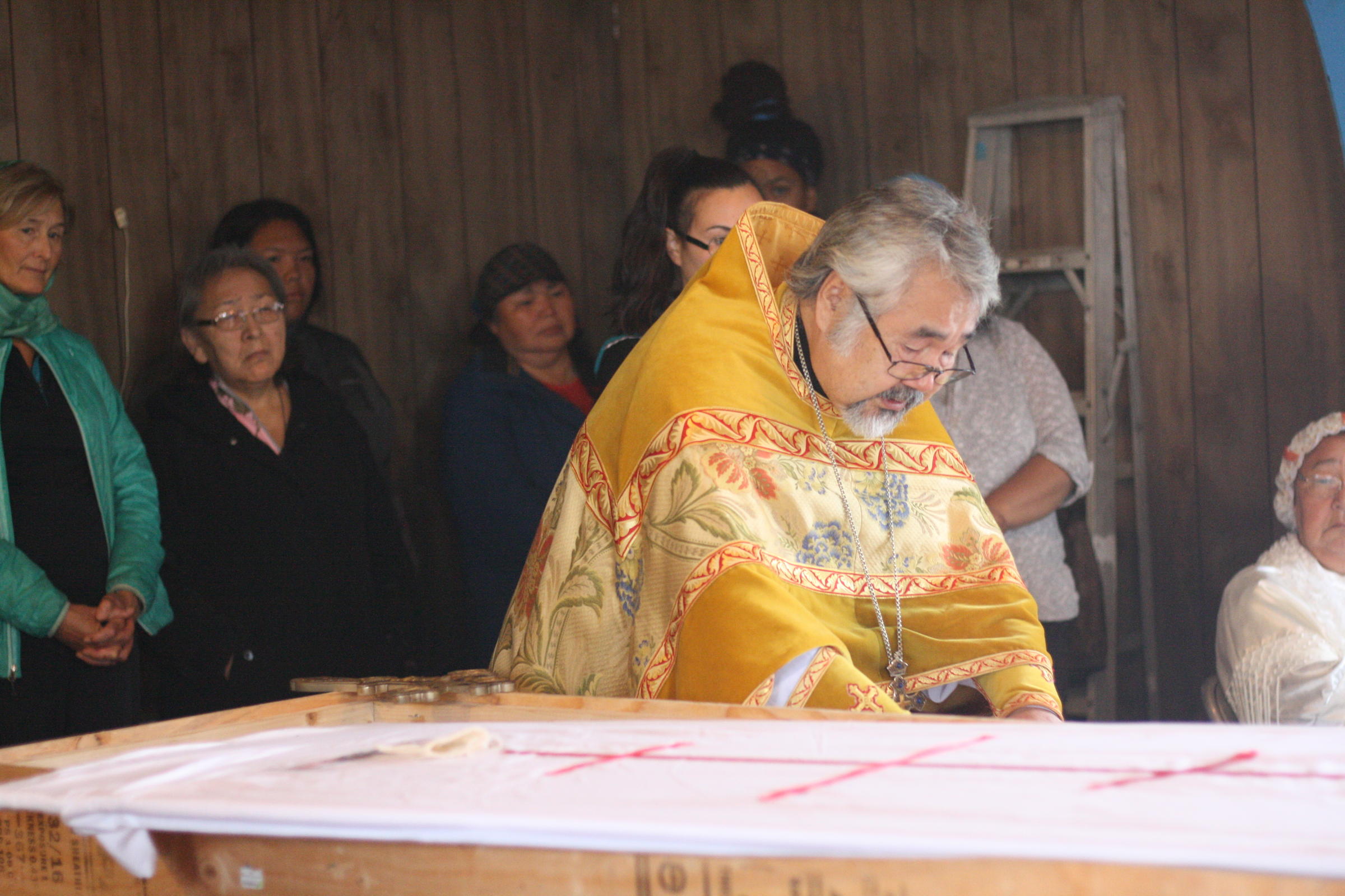The Rev. David Askoak places the prayers of absolution in a coffin. (Photo by Avery Lill/KDLG)