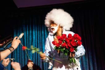 Juneau artist Tahir McInnis hands out roses as Tyquan during Femme Fatale Locals Night competition at the Rendezvous on Friday, Sep. 15, 2017. (Photo by Tripp Crouse/KTOO)