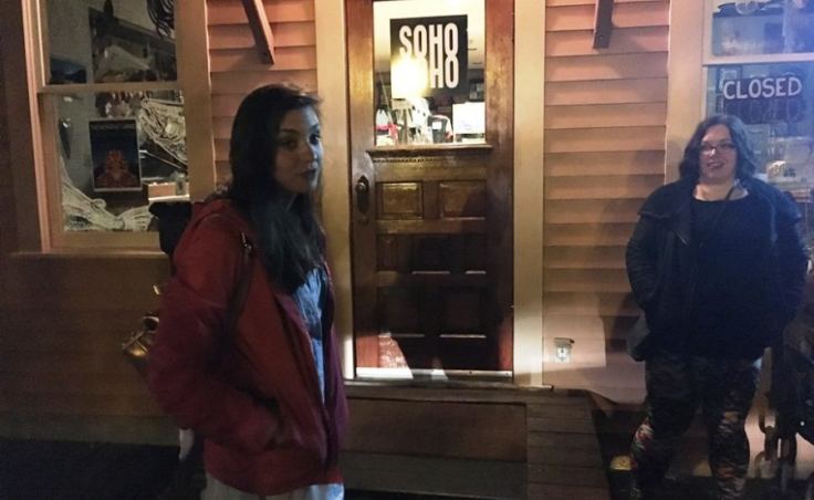 Ghost-tour guide Kelli Klees leads a group to some of Ketchikan’s haunted spaces. The Star Building on Creek Street, which houses Soho Coho, is home to a reported ghost. (Photo by Leila Kheiry/KRBD)