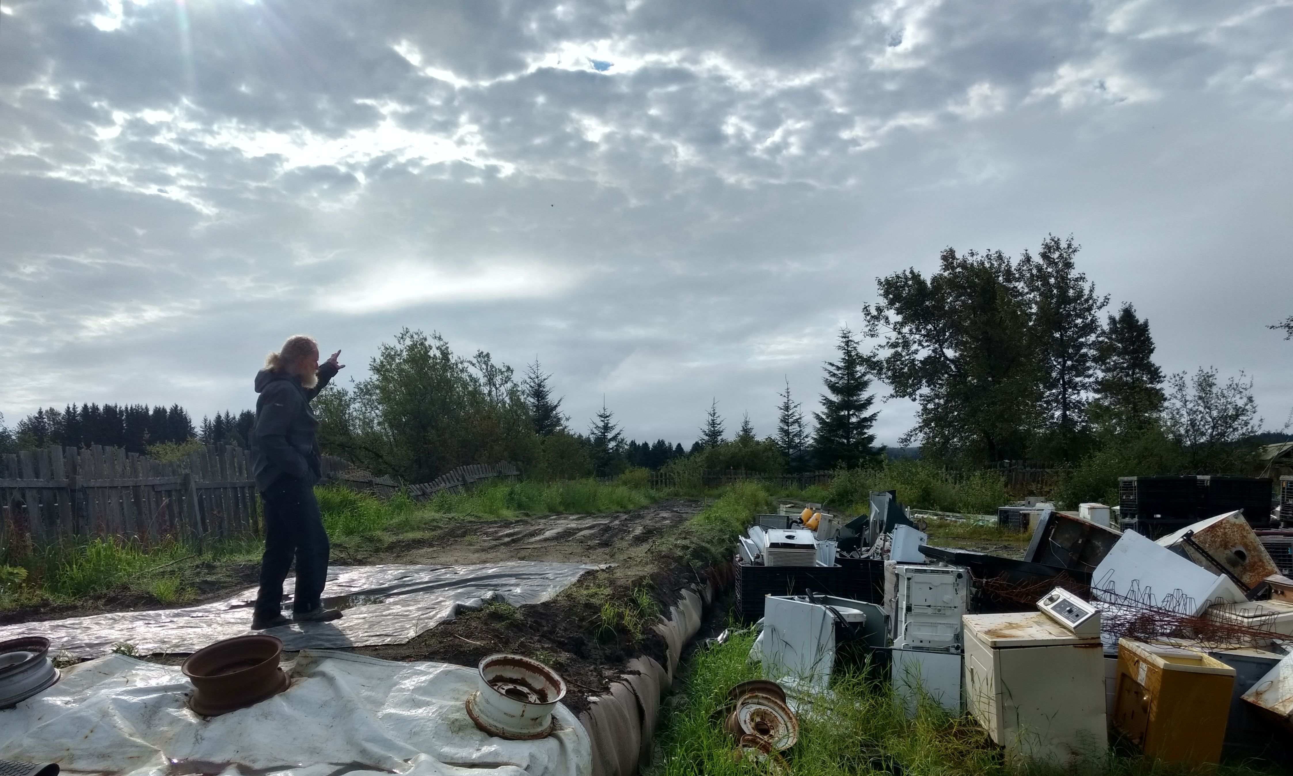 Gustavus’s Disposal and Recycling Center manager Paul Berry stands atop bales of municipal solid waste buried at the city’s landfill site. (Photo by Jacob Resneck/KTOO)