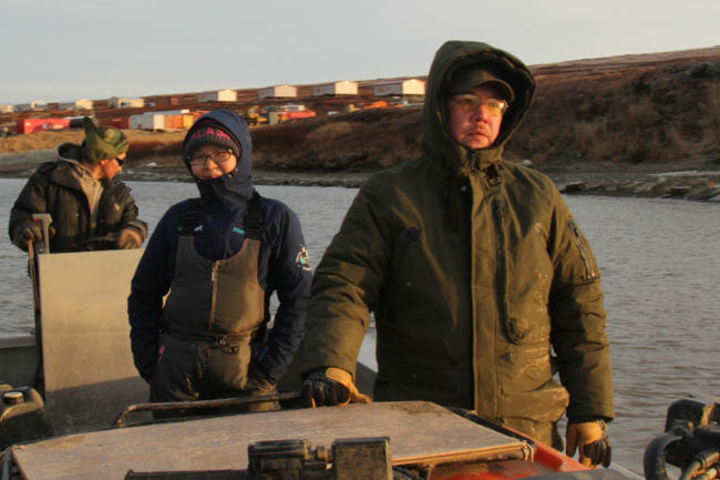 Residents of Newtok return from Mertarvik, seen in the background, the site the village hopes to move to. At right is tribal administrator Andrew John. (Photo by Rachel Waldholz/Alaska's Energy Desk)