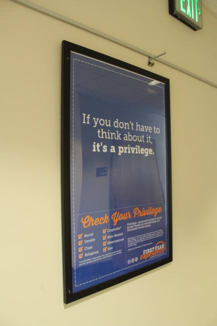 A poster hangs in a hallway at the University of Alaska Southeast during the second annual Power & Privilege Symposium on Nov. 7, 2017. (Photo by Adelyn Baxter/KTOO)