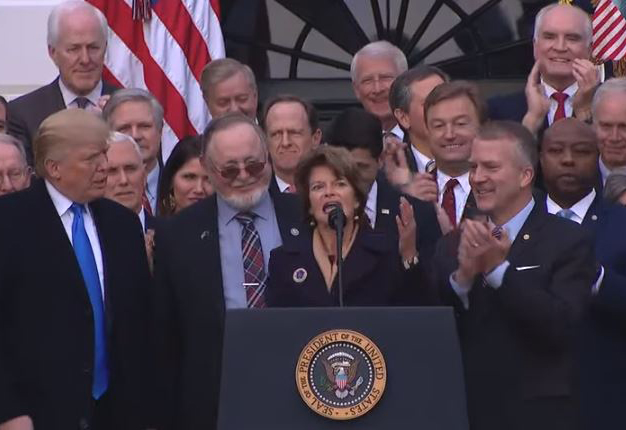 President Donald Trump congratulates U.S. Sen. Lisa Murkowski on passage of a bill to open the coastal plain of the Arctic National Wildlife Refuge to oil drilling. Rep. Don Young and Sen. Dan Sullivan flank Murkowski at the mic. (Video screenshot courtesy White House)