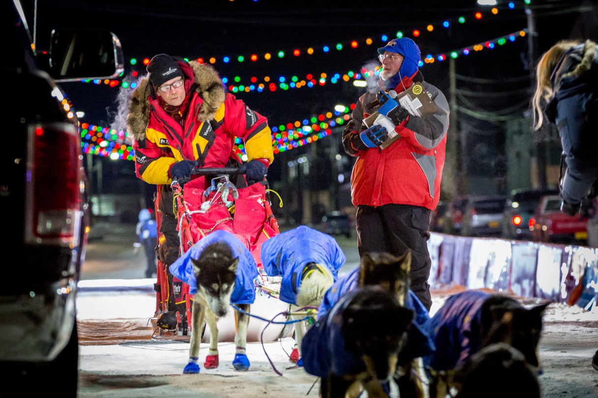 Mitch Seavey pulls his team past the finish line after officially checking off the Iditarod Trail. (Photo by David Dodman/KNOM)