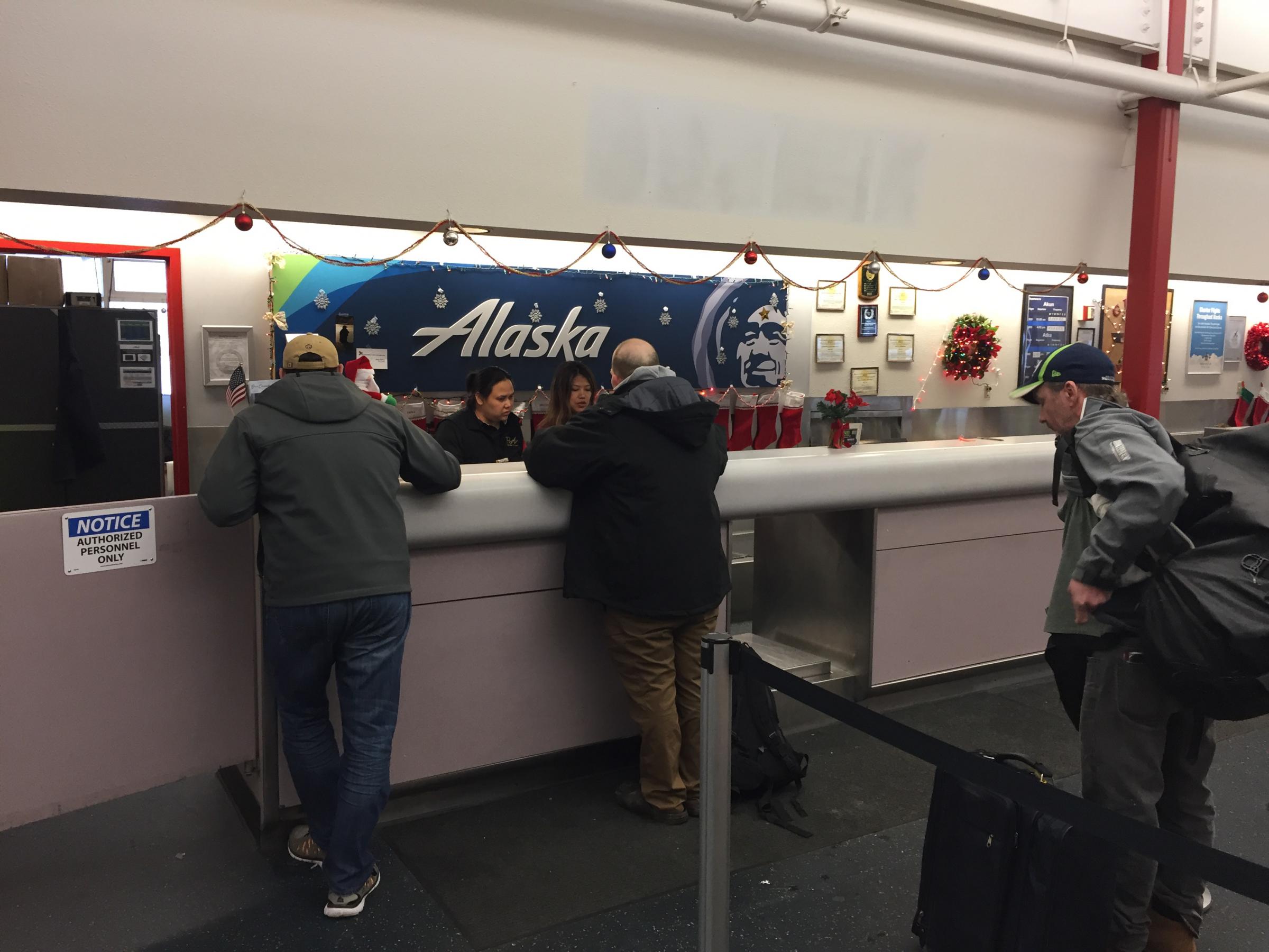 Unalaska Fire Chief Arlie Colvin, center, checks in for his flight Dec. 23, 2017. (Photo by Zoë Sobel/KUCB)