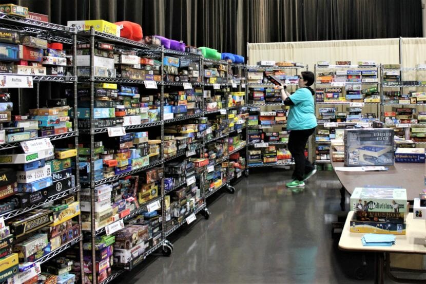 A volunteer returns a game to the game library at Platypus Con on Jan. 28, 2018. (Photo by Adelyn Baxter/KTOO)