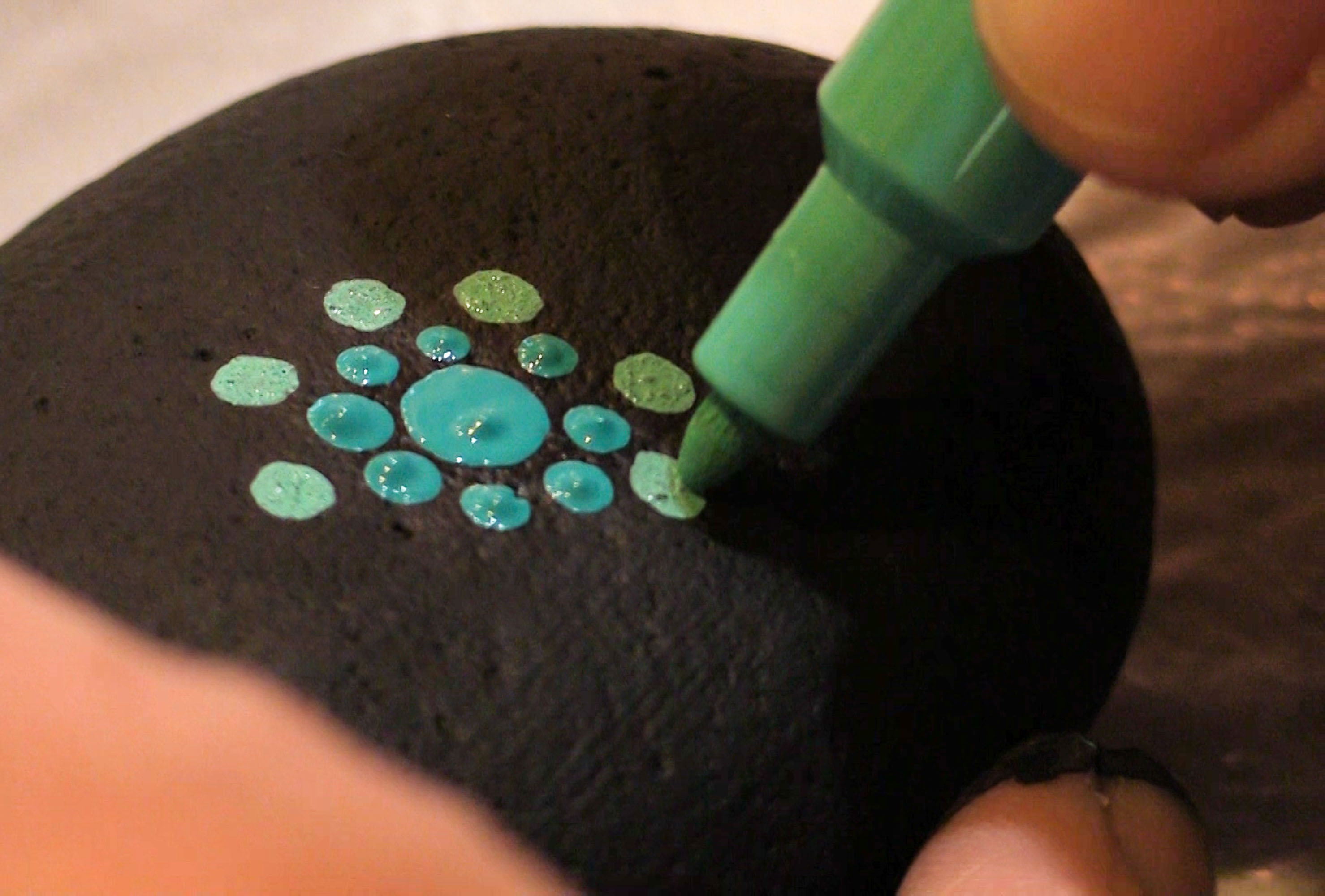 Heather Stemmerman uses a paint pen to create a design on a rock in Juneau. (Photo by David Purdy/KTOO)