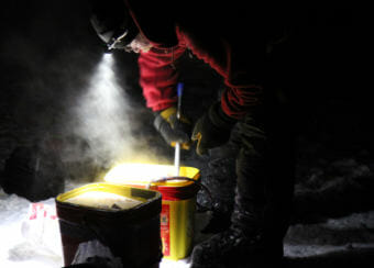 Mitch Seavey feeds his dogs shortly after arriving at the Skwentna checkpoint Sunday night in the 2018 Iditarod Trail Sled Dog Race. (Photo by Zachariah Hughes/Alaska Public Media photo)