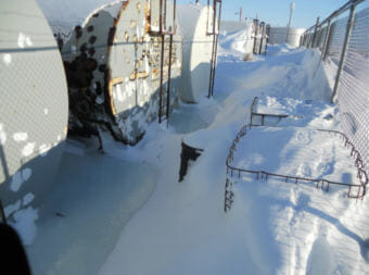 Several tanks stand in pools of heating oil that spilled during a tank transfer at the Savoonga Native Store in Savoonga.