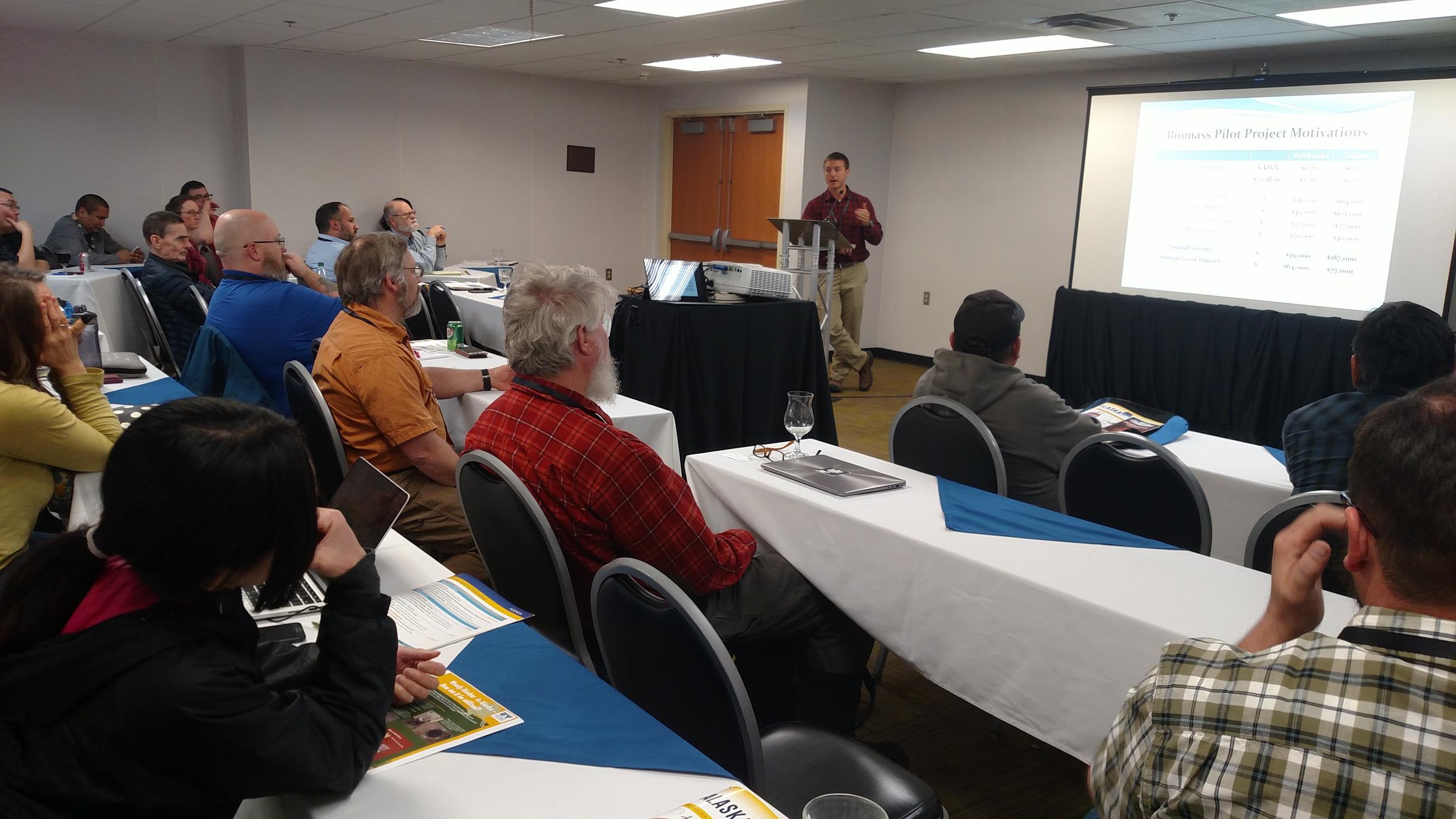 Fairbanks North Star Borough Energy Management Engineer Ben Loeffler talks with conferees about a biomass-gasification combined heat and power plant project at the Big Dipper Ice Arena during Tuesday’s Rural Energy Conference (Photo by Tim Ellis/KUAC)